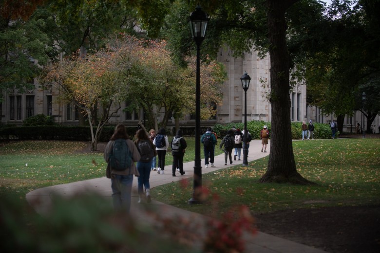 People walk along the sidewalks leading to the University of Pittsburgh’s Cathedral of Learning, Tuesday, Oct. 18, 2022, in Oakland. (Photo by Stephanie Strasburg/PublicSource)