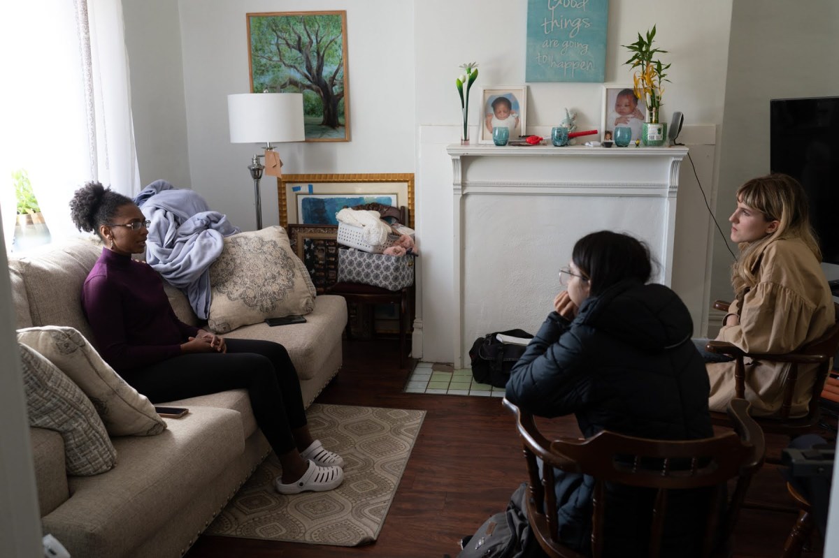 Chantele Mitchell-Miland talks with PublicSource education reporters Lajja Mistry and Emma Folts about participating in the Pittsburgh College Access Alliance study, Wednesday, Nov. 9, 2022, at her home in Larimer. Education is top of mind for her and her two sons, and has impacted how she’s experienced life in the Steel City. (Photo by Stephanie Strasburg/PublicSource)