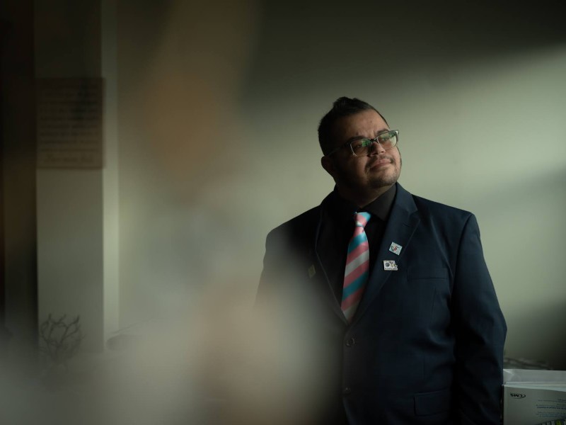 Aim Comperatore stands for a portrait at their Pressley Street High Rise apartment on Wednesday, Jan. 25, 2023, in East Allegheny. (Photo by Stephanie Strasburg/PublicSource)