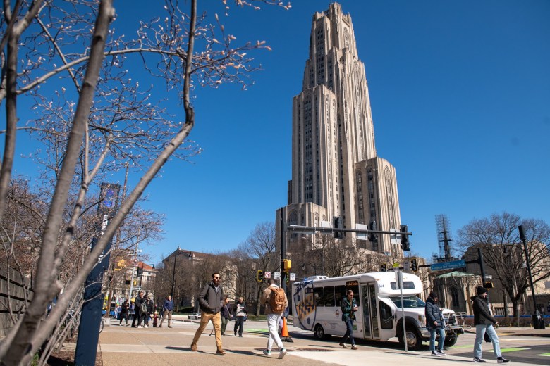 A University of Pittsburgh bus drops people off by the Cathedral of Learning on Thursday, March 30, 2023, in Oakland. (Photo by Stephanie Strasburg/PublicSource)