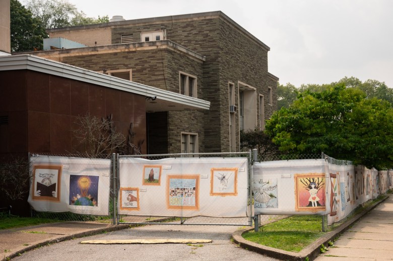 Drawings honoring those lost in the 2018 Pittsburgh synagogue massacre adorn the chain link fence surrounding the Tree of Life synagogue on Wednesday, August 2, 2023, in Squirrel Hill. In 2018, the place of worship was the site of the most fatal antisemitic attack in the nation. he Holocaust Center of Pittsburgh, currently located at Chatham University, will be housed in the new Tree of Life building, which does not yet have an opening date. The space will provide a central location for worship, healing and education. (Photo by Stephanie Strasburg/PublicSource)