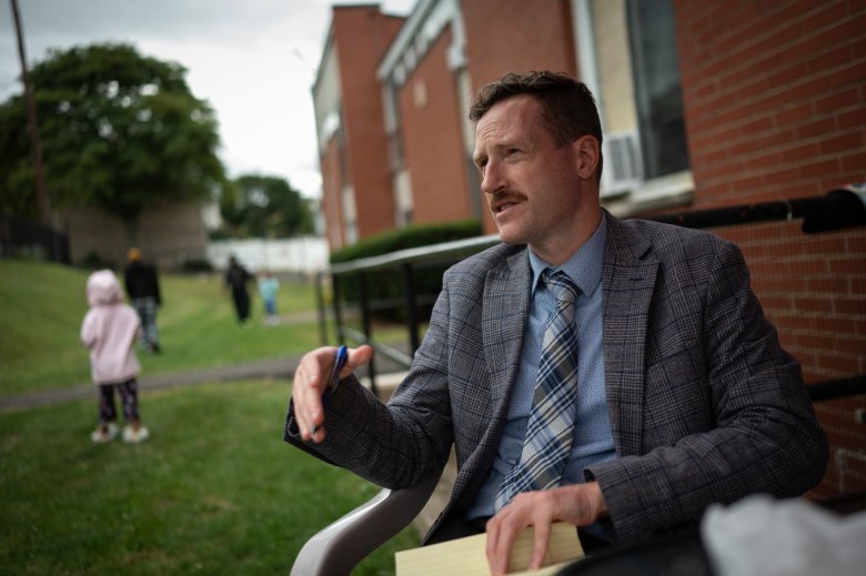 Dan Vitek, the Community Justice Project lawyer representing Hi View Gardens tenants, talks with tenant council members gathered for a meeting outside Hi View on Tuesday, Sept. 26, 2023, in McKeesport. (Photo by Stephanie Strasburg/PublicSource)