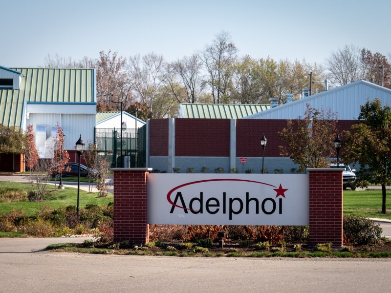 A white sign reads "Adelphoi" in front of several buildings in Latrobe.