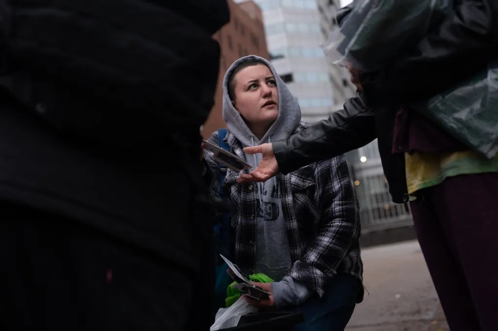 Lia S., who declined to share her last name, with Community Care & Resistance In Pittsburgh (CCRIP), gives out socks, batteries, and other supplies to people living outside on a rainy Sunday, Oct. 29, 2023, in Downtown Pittsburgh. The CCRIP team has remained busy since they started their street outreach about a year prior in response to the shutdown of the Stockton Avenue encampment on the North Side. (Photo by Stephanie Strasburg/PublicSource)