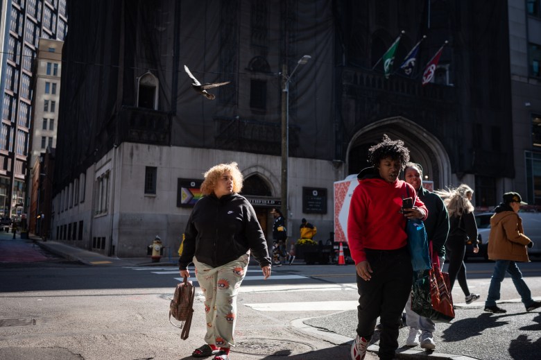 Pedestrians walk through a block of sunshine across from the Smithfield United Church of Christ, on Friday, Nov. 3, 2023, in downtown Pittsburgh. The church held a winter emergency shelter for decades but the church says DHS did not reach out for them to reopen for winter 2023. (Photo by Stephanie Strasburg/PublicSource)