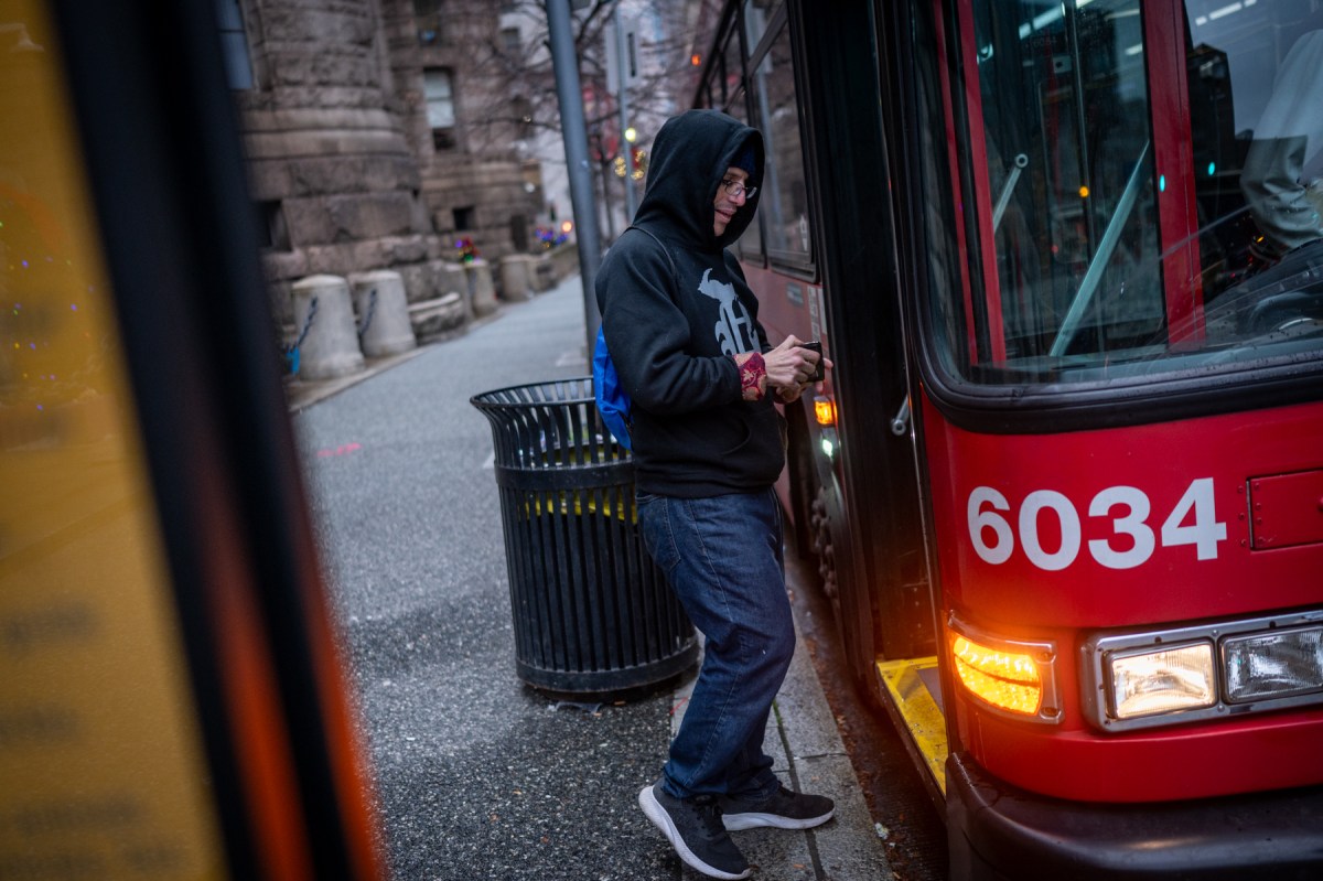 Russell Beyer, a volunteer with Community Care & Resistance In Pittsburgh, boards a bus to help a fellow Second Avenue Commons resident to their eviction hearing, Wednesday, Nov. 22, 2023, in downtown Pittsburgh. “The whole point of these SROs is you’re housing homeless people,” said Beyer. (Photo by Stephanie Strasburg/PublicSource)