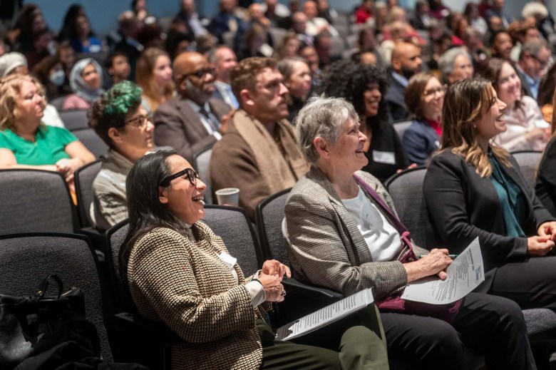 Monica Ruiz smiling in an auditorium full of people