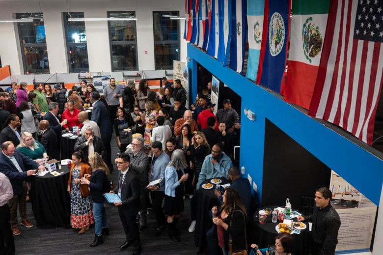 A crowd of people standing in a room with flags.