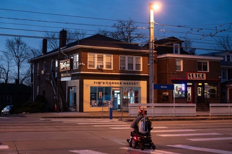 A man riding a scooter on a city street.