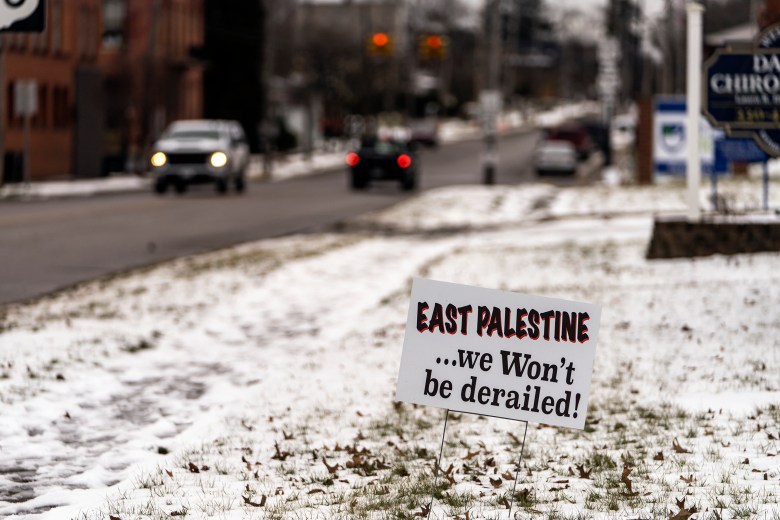 A snowy street with a sign saying East Palestine.. we won't be delayed.