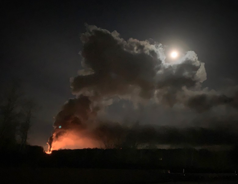 fire and smoke drift into a night sky