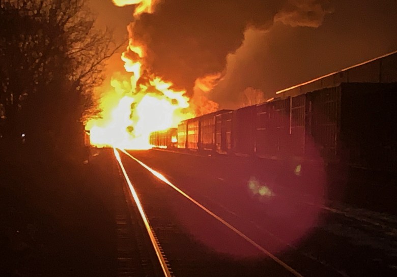 A fire burns at the far end of a train