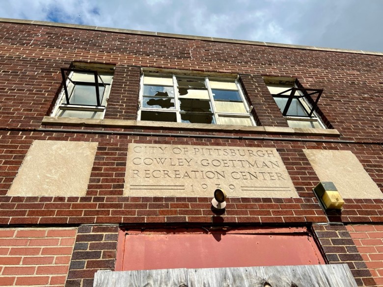 Broken windows above the entrance sign for the Cowley Rec Center in Troy Hill