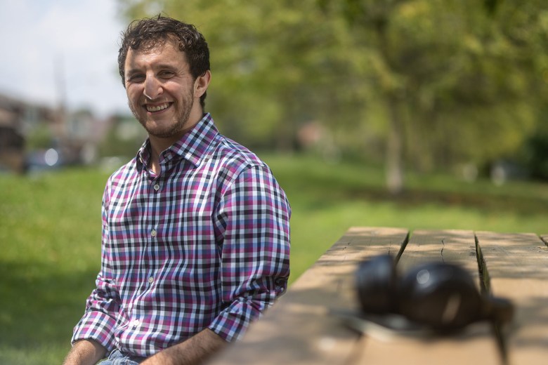 Eli Kurs-Laski sitting on a park bench at Frick Park. (Photo by Benjamin Brady/PublicSource)