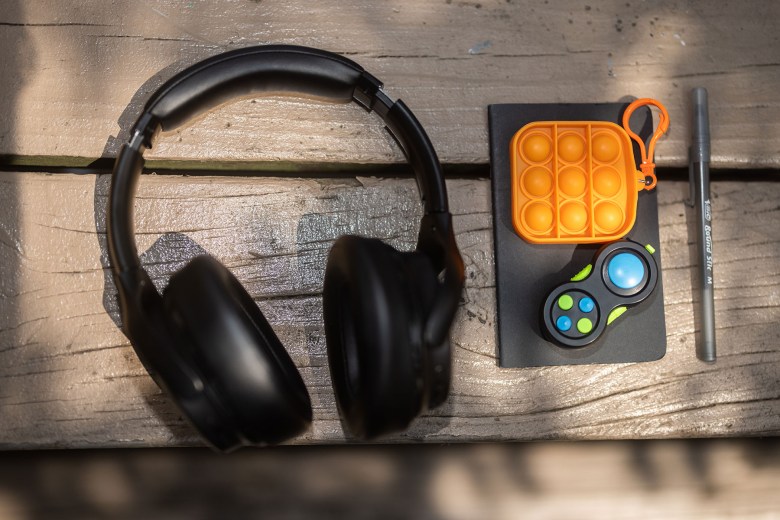 Eli’s headphones, fidget toys, notebook, and pen that he normally carries with him in his bag. (Photo by Benjamin Brady/PublicSource)