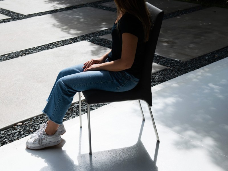 Jane sits in a chair outside, her hands folded.