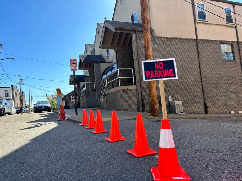 An arrangement of orange cones and a sign that reads "No Parking" in front of the Oakland Food Pantry.