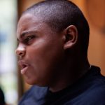 Deahmi Mobley (right), a freshman at Central Catholic High School, talks about his essay decrying youth violence and his subsequent involvement in the Do the Write Thing program, at the PublicSource office in Uptown Pittsburgh on Aug. 5, 2022. (Photo by Quinn Glabicki/PublicSource)