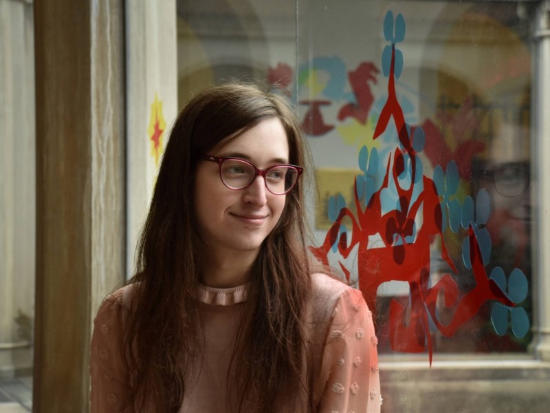 Luna Olivia Lindstrom sits in the Frick Fine Arts Building at the University of Pittsburgh on Wednesday, March 22, 2023. (Photo by Amaya Lobato Rivas/PublicSource)