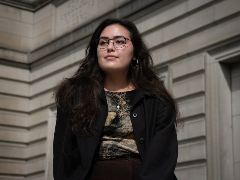 Cynthia McMahan sits outside of the Oakland branch of the Carnegie Library of Pittsburgh on October 5, 2023. McMahan recognizes that not all Pittsburgh residents have equal access to such “Palaces for the People.” (Photo by Amaya Lobato Rivas/PublicSource).