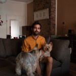 Andy Kelemen sits on the couch with his two dogs in his "quirky as hell" home in Central Lawrenceville. (Photo by Amaya Lobato Rivas/PublicSource)