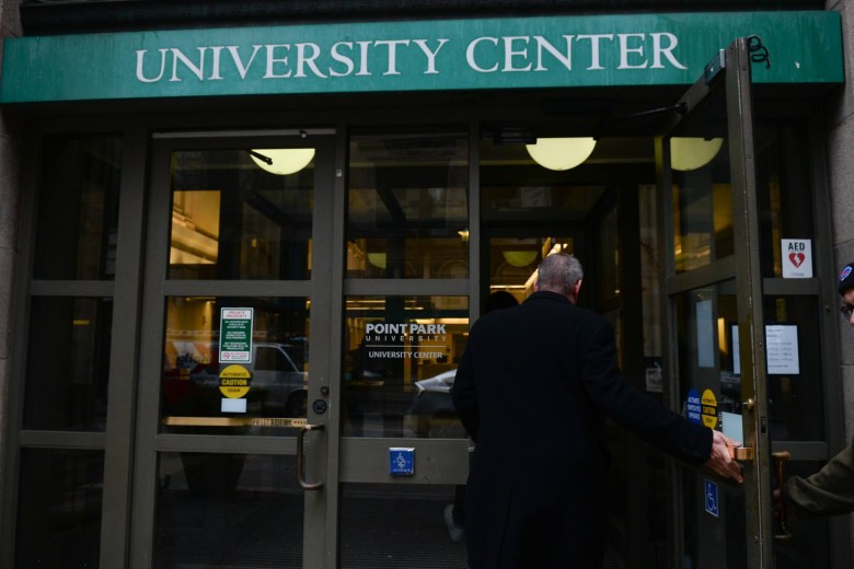 Chris Brussalis, president of Point Park University, walks into a university building, his back turned.