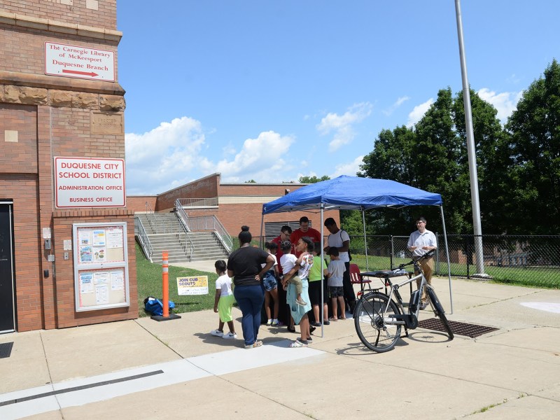 Kids and adults participate in a Science, Technology, Engineering and Mathematics walk-up program at the Duquesne branch of the Carnegie Library of McKeesport, which is located in the Mon Valley city's school, on July 22, 2022. (Photo by Clare Sheedy/PublicSource)