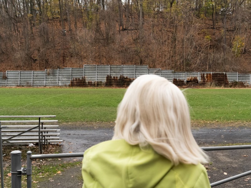 Pittsburgh Parks Conservancy President and CEO Cathy Qureshi looks out on a tarnished retaining wall at a sports field at McKinley Park in Pittsburgh's Beltzhoover neighborhood on Nov. 17, 2022. (Photo by Benjamin Brady/PublicSource)