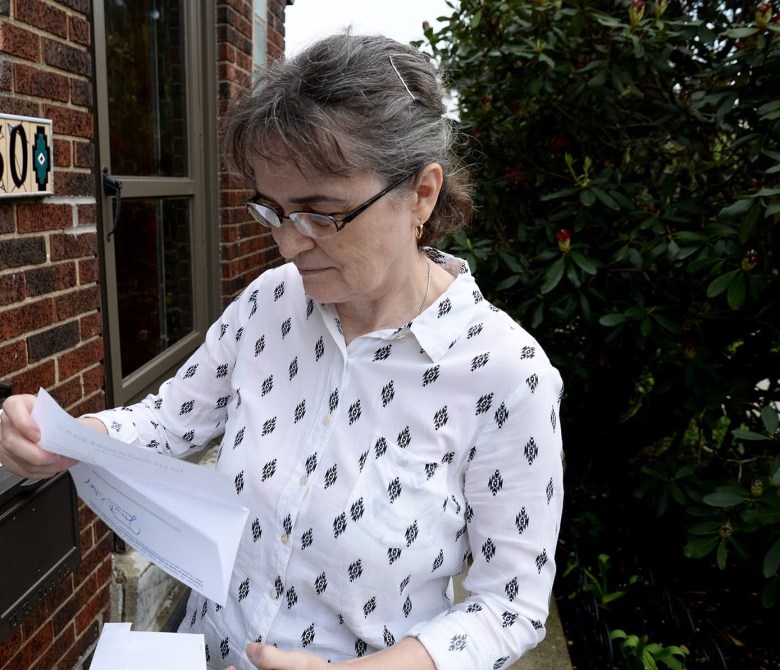 Flavia Laun reads one of the many letters she has received from attorneys offering to represent her in the property tax appeal filed by the Woodland Hills School District. “Shall I lose an extra $1,000 paying an attorney?” (Photo by Clare Sheedy/PublicSource)