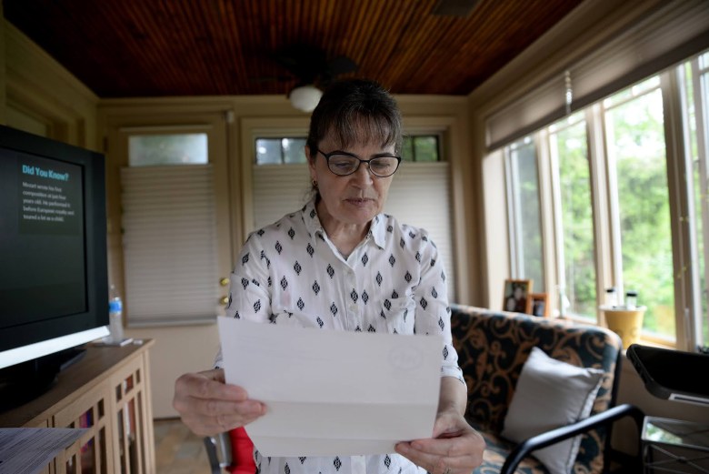 Flavia Laun of Churchill reads the “Dear taxpayer” letter she got from the Woodland Hills School District, which started the assessment appeal process. (Photo by Clare Sheedy/PublicSource)