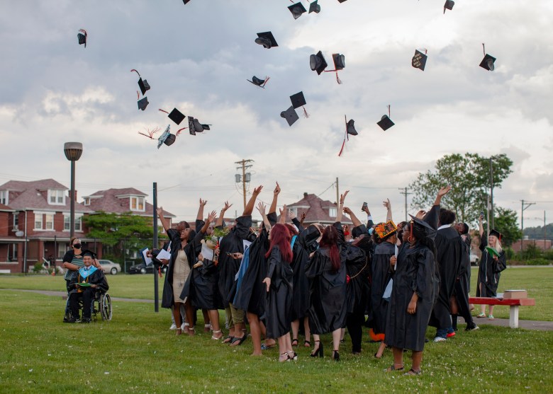 Clairton High School graduates toss their caps in the air outside of the Clairton Education Center on June 9, 2021.