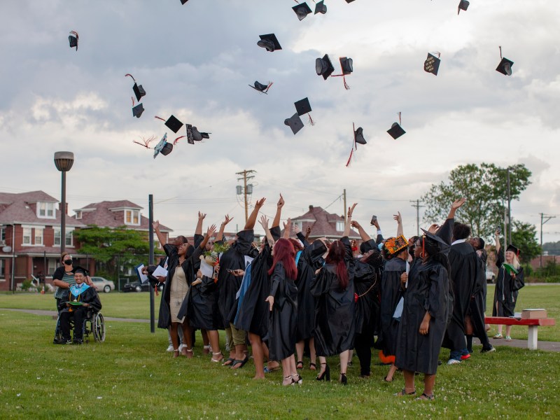 Clairton High School graduates toss their caps in the air outside of the Clairton Education Center on June 9, 2021.