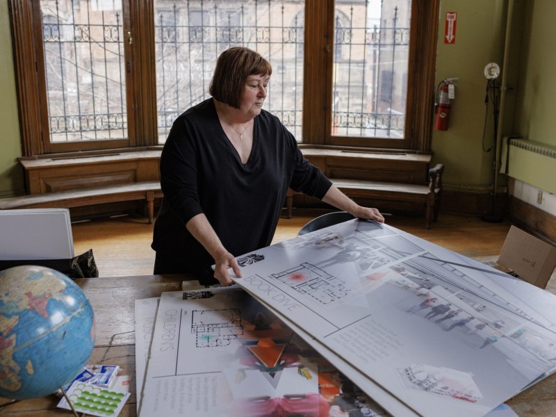 Vicki Vargo, executive director of the Braddock Carnegie Library, examines plans for the renovation of the 134-year-old building. (Photo by Quinn Glabicki/PublicSource)