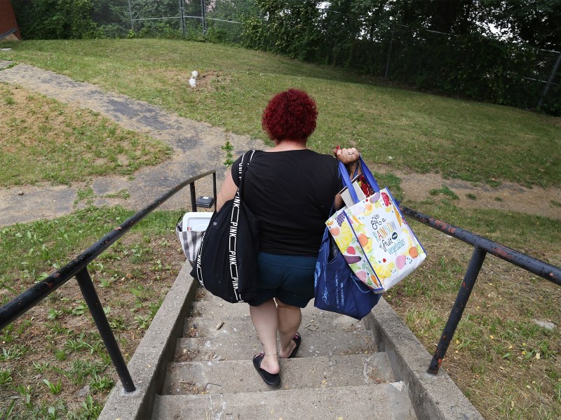 Beatrice Román carries belongings to a new apartment in Hi View Gardens on June 10, 2021. (Photo by Ryan Loew/PublicSource)