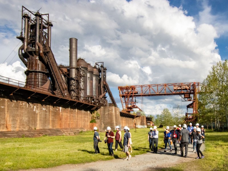 A tour group experience an industrial tour in front of Carrie Blast Furnaces.