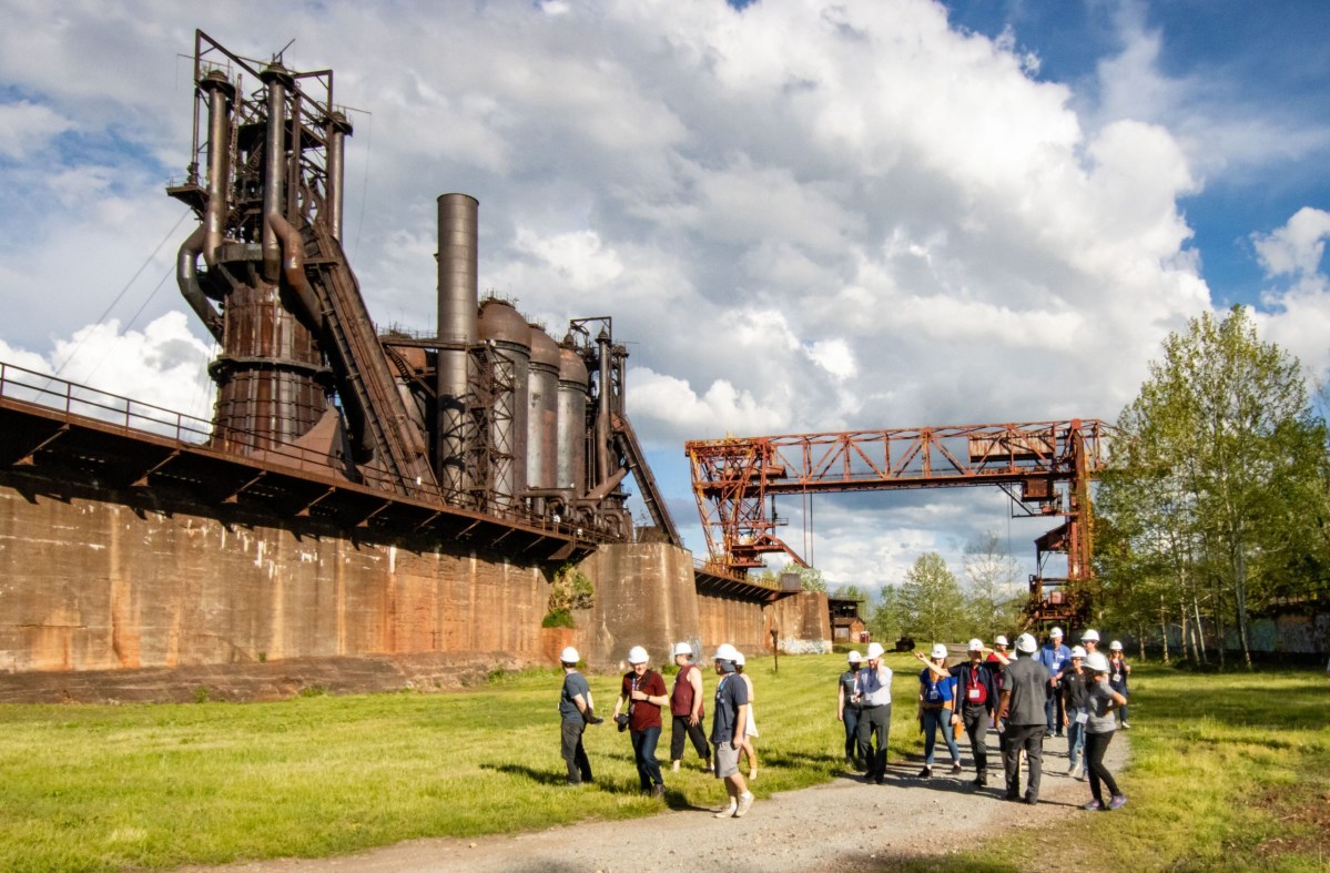 A tour group experience an industrial tour in front of Carrie Blast Furnaces.