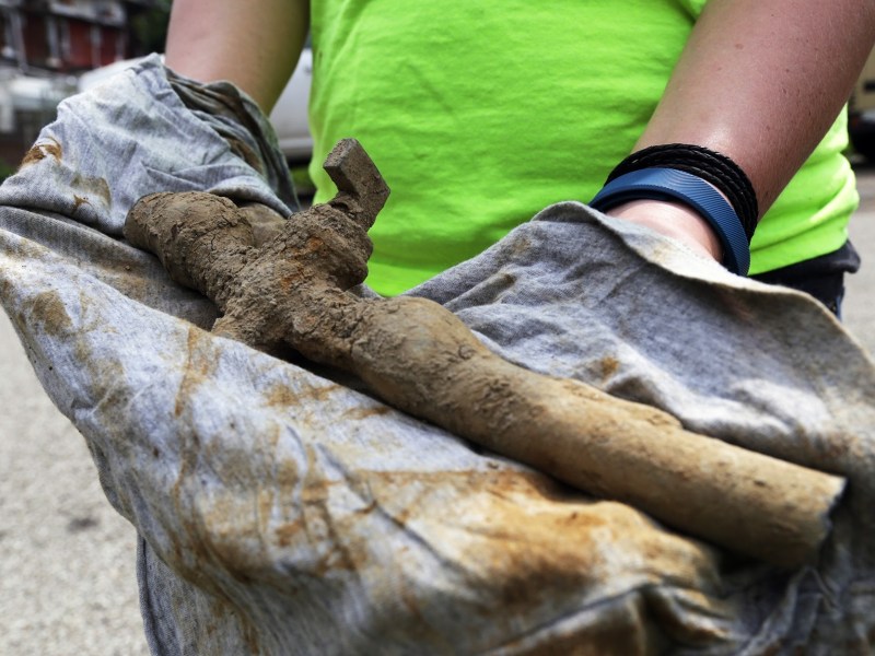 A PWSA project manager holds a portion of a removed lead service line. (Photo by Ryan Loew/PublicSource)