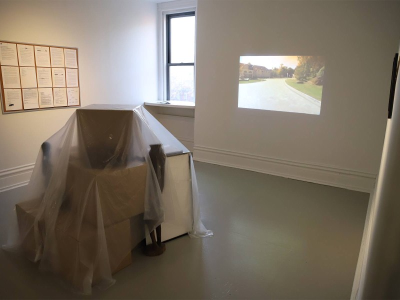 Boxes full of items suggesting Black ownership, removed from Shirley Salmon-Davis' East Liberty house, are the centerpiece of an installation art exhibit by Harrison Kinnane Smith at the Mattress Factory in Central Northside. The house was appraised twice — once with a Black person presenting as the owner, and with the African American-themed items, and once with a white person and without the items. The difference was $36,000. (Photo by Ryan Loew/PublicSource)