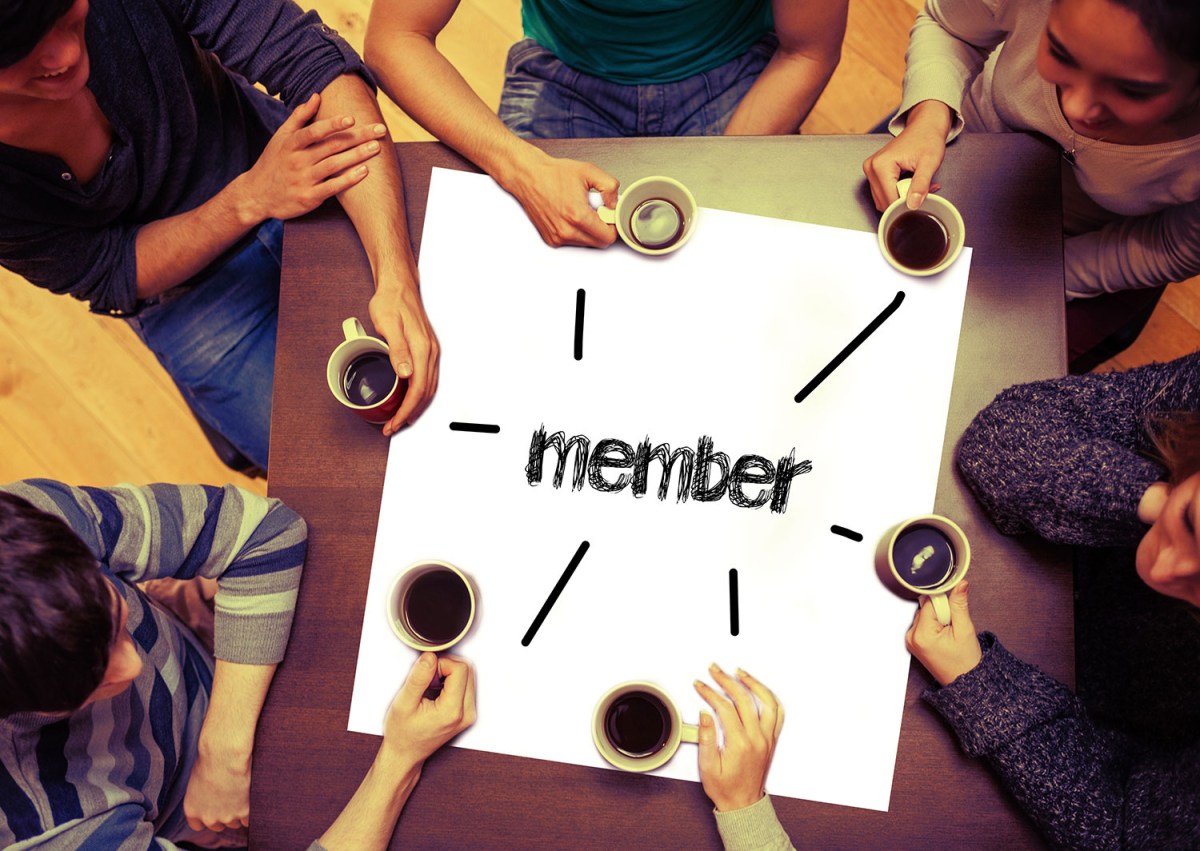 stock image of people holding coffee around a white poster with member written on it