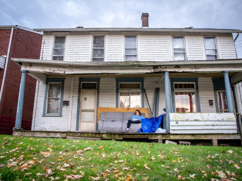 Patricia LaChoppa sits on the front porch of the duplex she rents in McKeesport. While the Allegheny County Health Department has imposed $15,500 in penalties on her landlord, she continues to live without heat. (Photo by Kaycee Orwig/PublicSource)