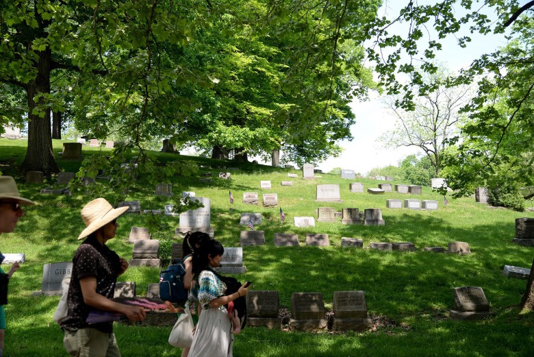 Lena Chen (front right) and attendees of the Chinese Cemetery and Squirrel Hill Photo Tour walk to the Chinese Cemetery section of Homewood Cemetery. (Photo by Clare Sheedy/PublicSource)